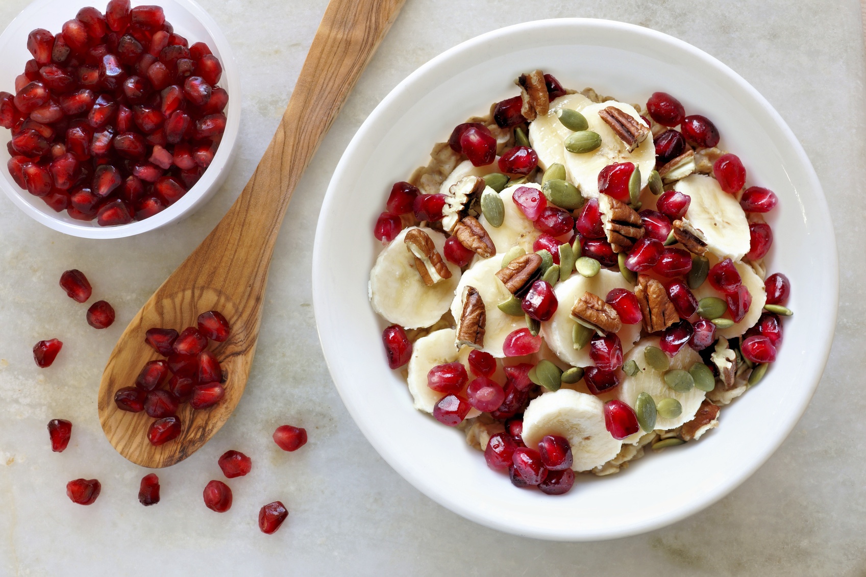 Healthy breakfast oatmeal with pomegranate, bananas, seeds and nuts