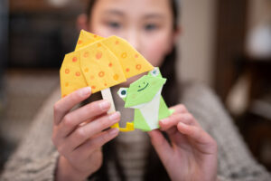 A girl with an origami frog