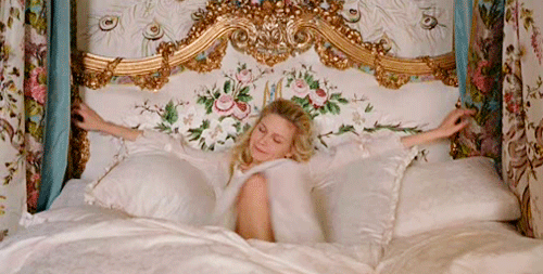 gif of a women getting comfy in a bed
