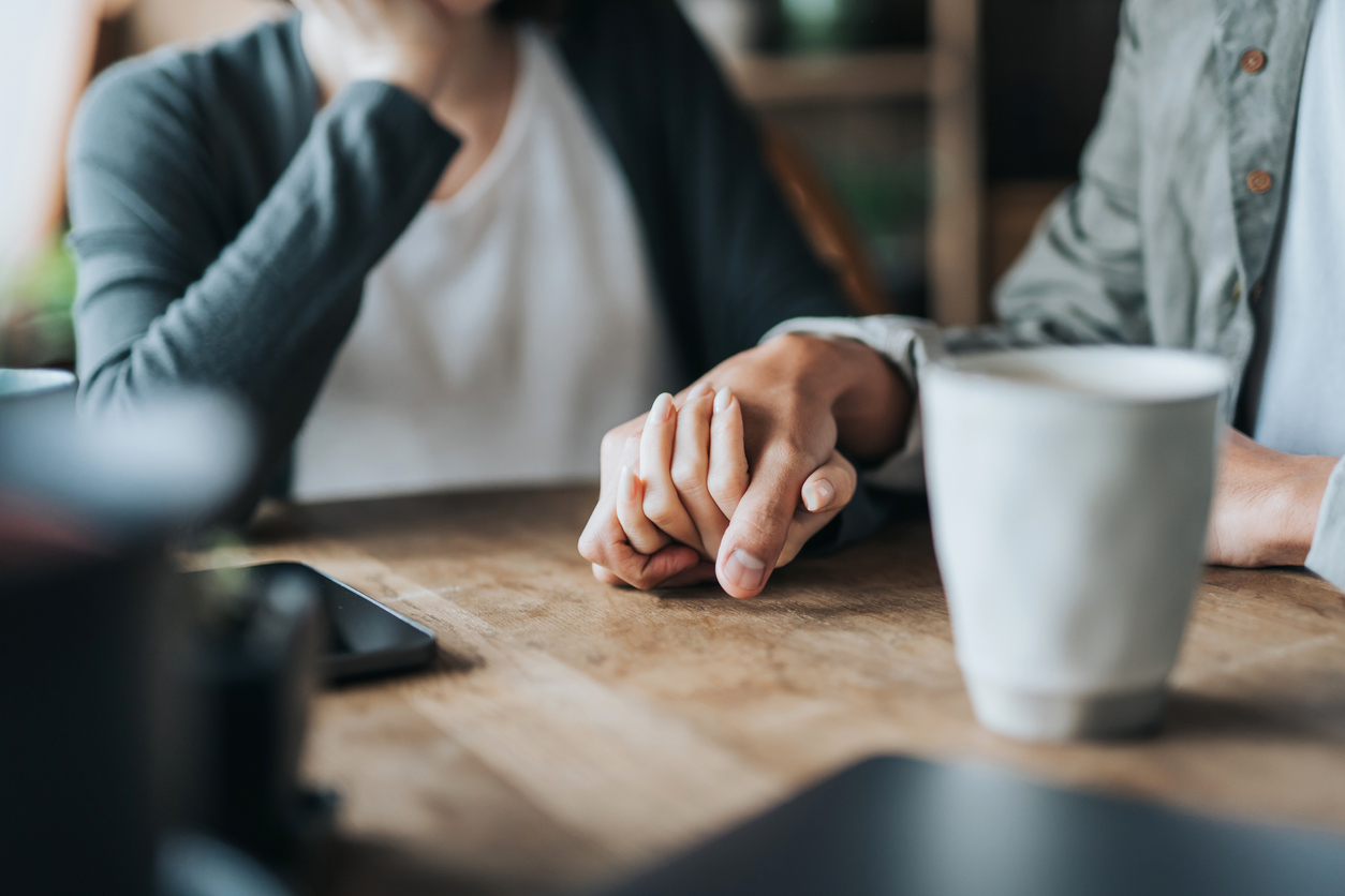 Close up of young Asian couple on a date in cafe, holding hands on