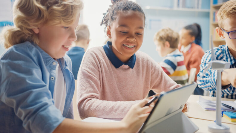 In the Elementary School: Girl and a Boy Work as a Team Using Tablet ...