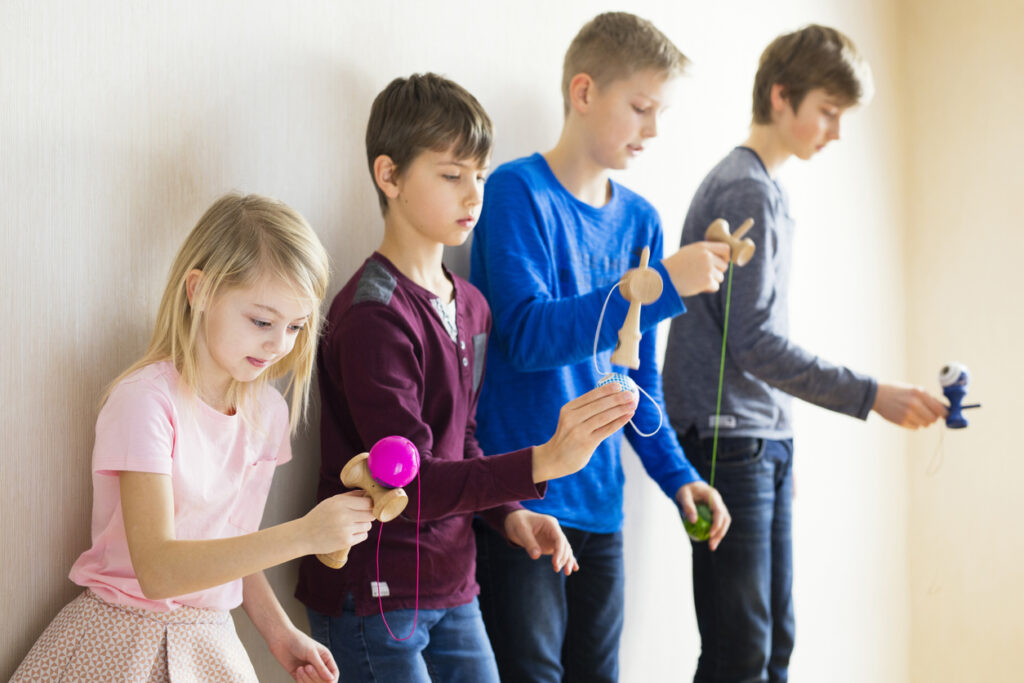 Group of kids playing kendama together
